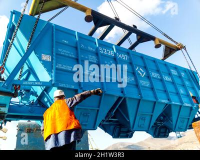 Novorossiysk, Russia - 10 Ottobre 2017: Carro della tramoggia di scarico su una nave da carico. Le operazioni di sollevamento nel porto. Foto Stock