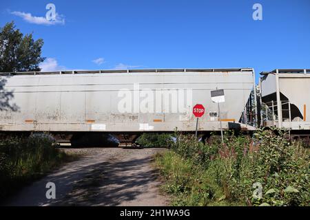 Un treno supera un segnale di stop a un incrocio. Foto Stock