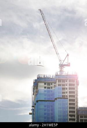 Alto edificio in costruzione con gru in cima. Spazio di copia. Foto Stock