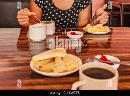 Semplice albergo ostello colazione con pane tostato burro marmellata e caffè nero su tavolo di legno a Kathmandu Nepal. Foto Stock