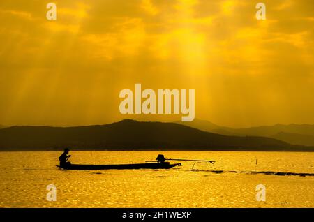 Silhouette sito in costruzione galleggiante sul fiume con la riflessione sul tramonto. Il concetto di costruzione. Foto Stock