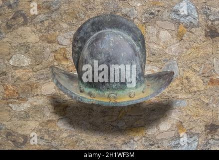 16h secolo crestato casco morion. Isolato su fondo muro di pietra Foto Stock