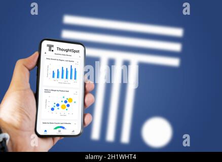 San Francisco, CA, USA, luglio 2021: Una mano che tiene un telefono con l'app ThoughtSpot sullo schermo. Sfondo blu con ThoughtSpot sfocato è un ameri Foto Stock