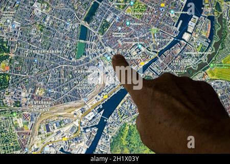 Udine, Italia. 21 agosto 2021. La vista satellitare di Gooble Maps di Copenhagen, capitale della Danimarca, indicata con un dito Foto Stock