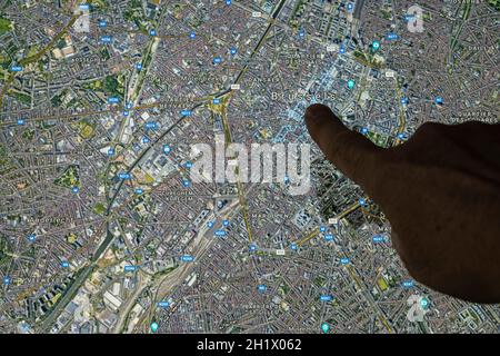 Udine, Italia. 21 agosto 2021. La vista satellitare di Gooble Maps di Bruxelles, capitale del Belgio, indicata con un dito Foto Stock