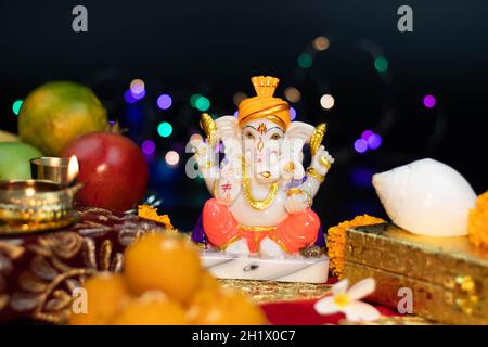 Primo piano di Dio indù Ganesha Ganpati Bappa Morya in posa seduta su Un effetto bokeh colorato sfondo nero. Per le preghiere sul Diwali Puja nuovo anno profondo Foto Stock