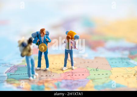 Le persone in miniatura, due zaino in spalla godono di viaggio scoperta a Amazing sulla mappa del mondo. Foto Stock