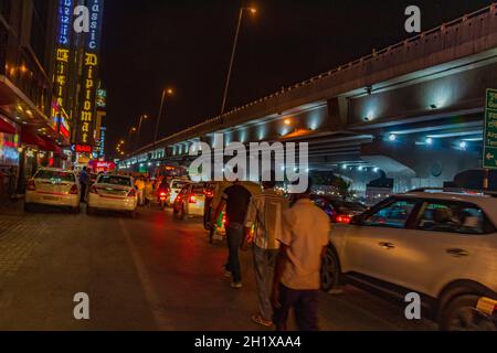 Vita notturna e grande traffico con Tuk Tuks autobus e la gente a Nuova Delhi Delhi India. Foto Stock
