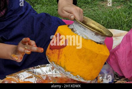 Donna indù indiana che decora il vaso, con curcuma e vermilion, per offrire cibo alla dea mahan kali come bonam durante il festival Bonalu Foto Stock