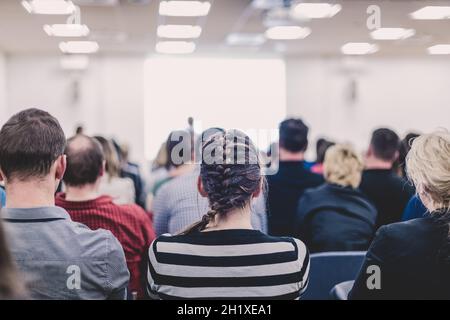 Business e imprenditorialità simposio. Altoparlante femmina dando un talk durante la riunione di affari. Il pubblico in sala conferenza. Vista posteriore della parte non riconosciuta Foto Stock