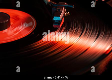 Dettaglio dell'ago su disco in vinile su giradischi, immagine con luce scarsa e riflesso Foto Stock