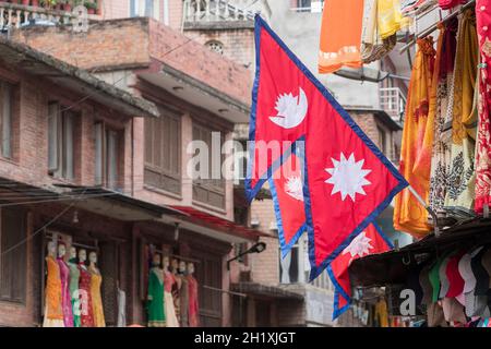 Rosso, bandiera blu, bandiera del paese Nepal nel mezzo di una città di Kathmandu, Nepal. Foto Stock