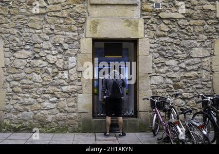 Dettaglio del giovane uomo che prende soldi da una banca, contanti Foto Stock