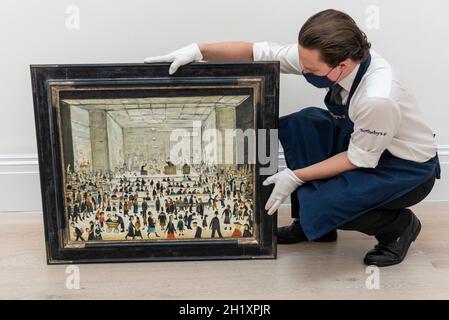 Londra, Regno Unito. 19 ottobre 2021. L.S. Il “The Auction” di Lowry è presentato al Sotheby’s. È l'unico dipinto noto dell'artista di una sala d'asta e farà il suo debutto all'asta alla Londra di Sotheby questo novembre con una stima di £1.2 - 1.8 milioni. Credit: Stephen Chung / Alamy Live News Foto Stock