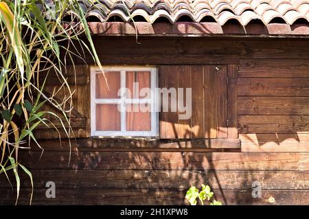 Una finestra in legno bianco con tende rosa di un bungalow in legno nella campagna toscana (Toscana, Italia, Europa) Foto Stock