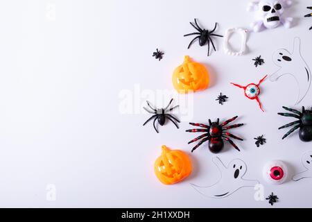 Composizione di decorazioni di Halloween con ragni, fantasma e zucca con spazio copia su bianco Foto Stock