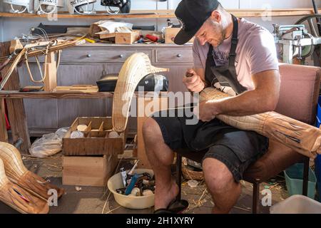 L'ex campione del mondo Patxi Tambourindeguy ripara un grande chistera nel suo laboratorio di pelota a Bidart, Francia Foto Stock