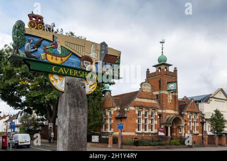 Tradizionale segno di villaggio di legno, scolpito da Stuart King, Church Street, Caversham, Reading, Berkshire, Inghilterra. Biblioteca Caversham sullo sfondo. Foto Stock