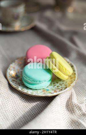 i tradizionali biscotti di macaron francesi colorati si trovano su un tavolo di legno, i macaron color pastello per il te' o il caffe' pomeridiano Foto Stock