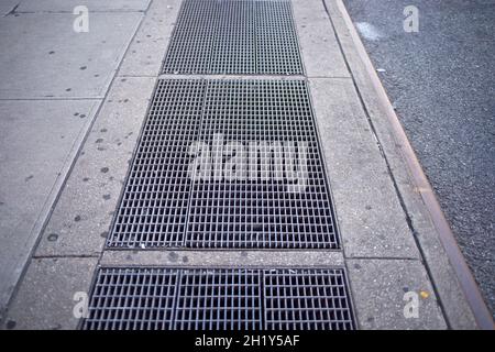 Prese della metropolitana su un marciapiede lungo una strada della città Foto Stock