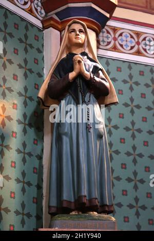 FRANCIA HAUTE-GARONNE (31) RIEUX-VOLVESTRE. STATUA DELLA CHIESA POLICROMA, BERNADETTE SOUBIROU Foto Stock