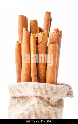 Bastoncini di cannella in sacchetto di sag su sfondo bianco Foto Stock