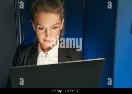 Tecnico femminile che utilizza il laptop per analizzare il server Foto Stock