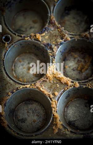 Una teglia per muffin vuota con briciole di torta Foto Stock