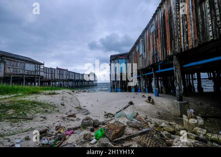 Vecchi e ramshackle moli di legno sporgono fuori nel mare a Hua Hin, Tailandia Foto Stock