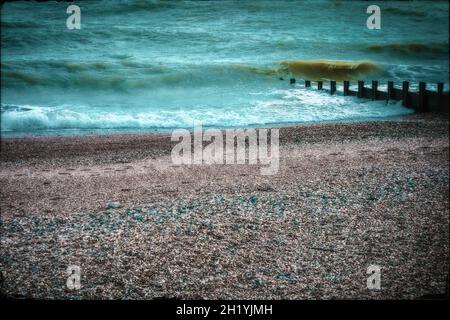 Paesaggio oscuro e moody di una spiaggia vuota in Hastings East Sussex Inghilterra con tonalità di colore freddo cross processed, preso il 31st luglio 2021 Foto Stock