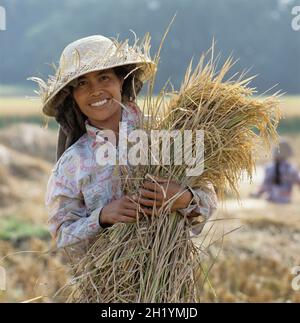 Giovane Bali che lavora nei campi e posa in paglia cappello, Ubud, Bali, Indonesia, Sud-Est asiatico Foto Stock