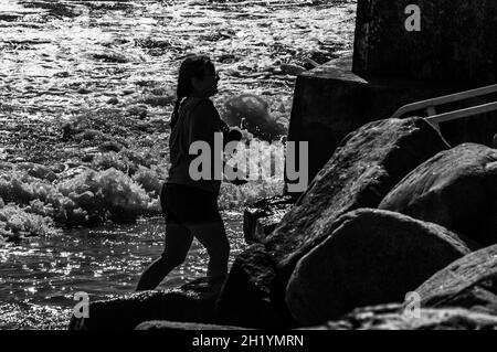 Una donna in vacanza è andata molto a lungo sulla spiaggia, e la gente le ha detto di stare attenti alla marea sta arrivando. Ma è stata sorpresa da Foto Stock