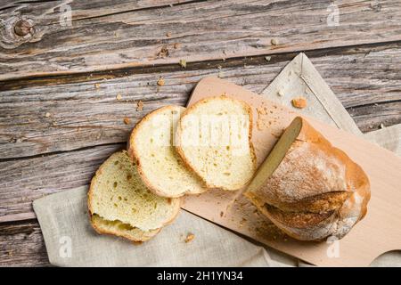 Pane fresco affettato e briciole su tavola di legno. Vista dall'alto Foto Stock