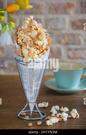 Una cialda a bolle d'aria con popcorn, salsa al caramello, arachidi e sale marino Foto Stock