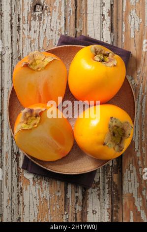 Persimions interi e tagliate a metà Foto Stock