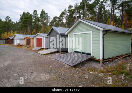 Case di legno colorate per tenere le barche in riva al lago. Parco Nazionale Stora Sjofallet, Svezia. Foto Stock