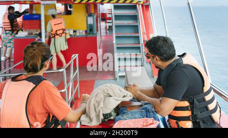 Vista posteriore dei passeggeri amanti in giubbotto di vita rilassante sul balcone che gode di vista dalla barca dell'isola di Samui in SEA.Happy coppia turisti casual fuori su Foto Stock