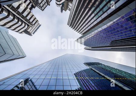 Guardando verso l'alto i blocchi di uffici skyward di Lloyd's, Willis Towers Watson, il Scalpel e il Cheesegrater; City of London, Inghilterra. Foto Stock