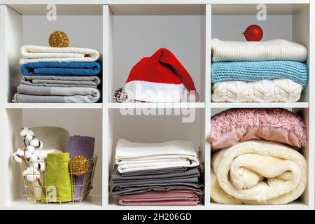 Biancheria da letto, asciugamani, lenzuola, coperte su scaffali decorati per Natale e Capodanno. Foto Stock