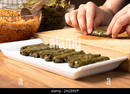 donna che prepara il sarma turco in cucina. Foto Stock