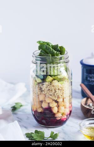 Layered con insalata di quinoa e verdure in un vasetto di vetro Foto Stock