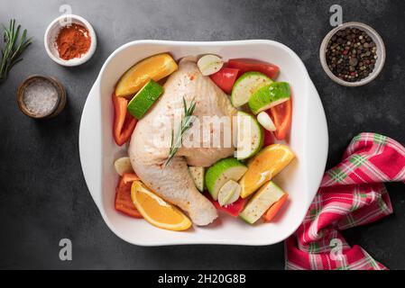 Carne di pollo cruda con verdure in padella di ceramica Foto Stock