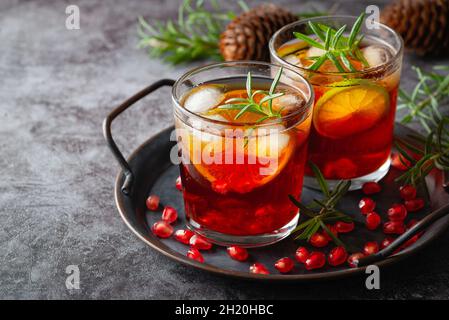 Cocktail di melograno decorato con lime, rosmarino e ghiaccio, bevanda fredda Foto Stock