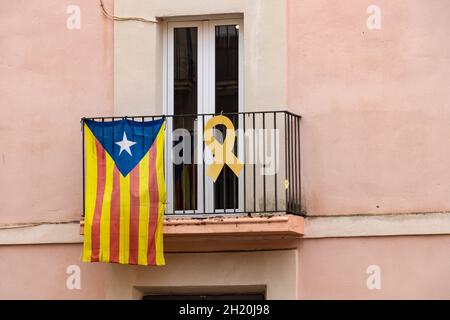 Bandiera d'indipendenza catalana e nastro giallo appeso a una finestra che chiede l'indipendenza della Catalogna e la libertà del politico imprigionato Foto Stock