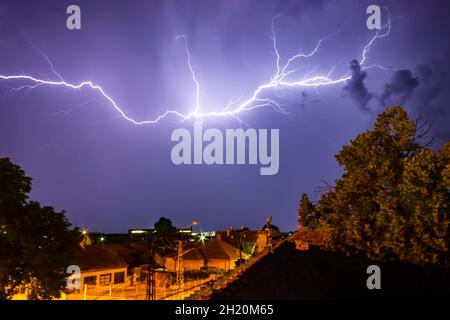 Immagine ipnotizzante di un cielo tempestoso sopra le case. Foto Stock