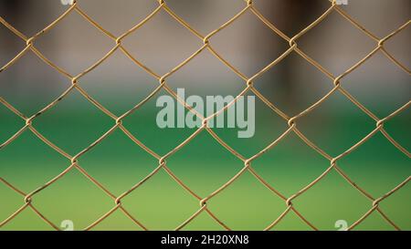 Primo piano di una vecchia recinzione a catena in un campo da calcio. Messa a fuoco selettiva Foto Stock