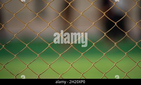 Primo piano di una vecchia recinzione a catena in un campo da calcio. Messa a fuoco selettiva Foto Stock