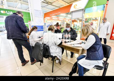 Non esclusiva: Una donna ottiene un colpo di vaccino contro Covid-19 in un punto di vaccinazione di massa nei locali di un centro commerciale, Zaporizhzhia, Southea Foto Stock