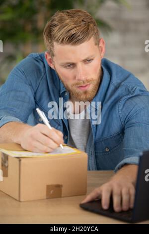 imprenditore che invia pacchi in un piccolo ufficio o a casa Foto Stock