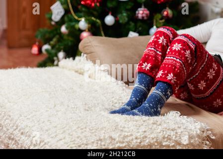 Persona che indossa calze e pigiami di Natale Foto Stock